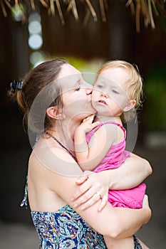 Mother kissing her little daughter