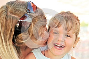 Mother kissing her little daughter