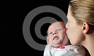 Mother kissing her new born baby