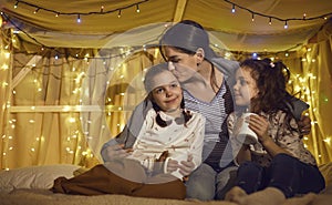 Mother kissing loving children while spending time together before bedtime