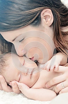 Mother kissing newborn baby