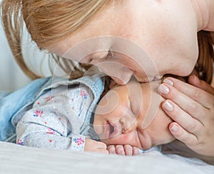 Mother kissing newborn baby