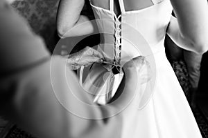 Mother laces the bride`s dress