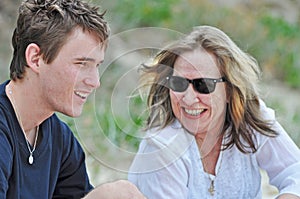 Mother laughing smiling loving sharing time with son on summer beach holiday