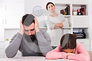 Mother lecturing husband and daughter