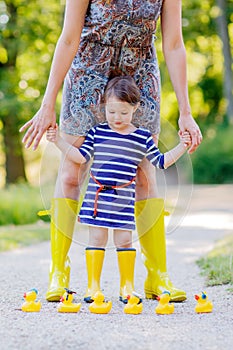 Mother and little adorable child in yellow rubber boots