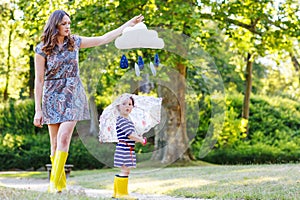 Mother and little adorable child in yellow rubber boots