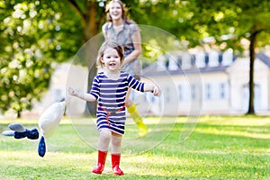 Mother and little adorable child in yellow rubber boots