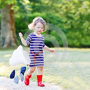 Mother and little adorable child in yellow rubber boots