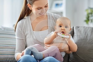 mother and little baby with teething toy at home