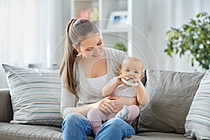 mother and little baby with teething toy at home