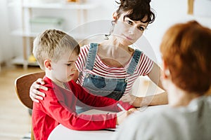 Mother and and little boy in red sweater learn by drawing during ADHD therapy