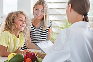 Mother and little boy during a visit to a dietitian preparing a healthy diet plan