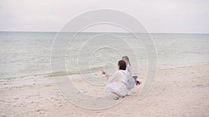 Mother With Little Child Blowing Soap Bubbles On Sea Beach Traveling with one Children Family Summer Vacation