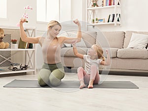 Mother and little daughter doing yoga together