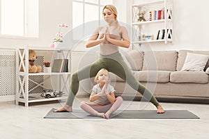Mother and little daughter doing yoga together