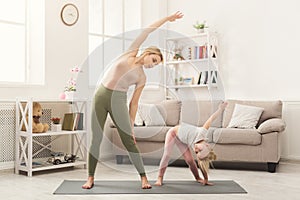 Mother and little daughter doing yoga together