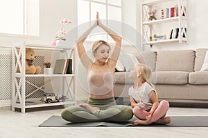 Mother and little daughter doing yoga together