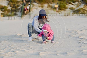 Mother and little daughter having fun on the beach. Authentic lifestyle image