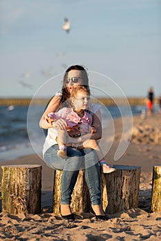 Mother and little daughter having fun on the beach. Authentic lifestyle image
