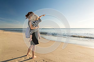 Mother with little daughter on her arm at the beach