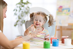 Mother and little daughter kid have a fun pastime with finger pints