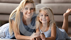 Mother little daughter lying on warm floor drawing enjoy leisure