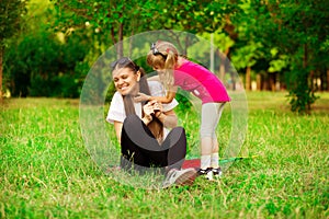 Mother and little daughter playing together in park. Outdoor Portrait of happy family. Happy Mother`s Day Joy.
