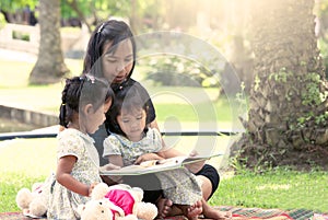 Mother and little daughter reading book together
