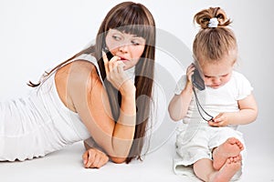 Mother and little daughter speaking by phone