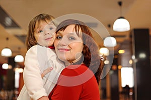 Mother with little daughter stand in cafe