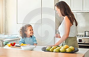 Mother and little daughter talking while mom teach her how to cook a vegetarian meal. Cooking with a little helper