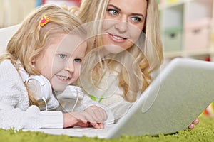 Mother with little daughter using laptop