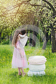 Mother and a little daughter walk in the spring blooming Apple