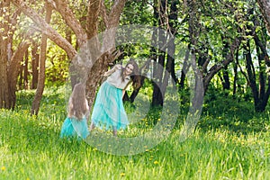 Mother and a little daughter walk in the spring blooming Apple