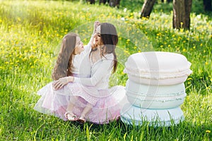 Mother and a little daughter walk in the spring blooming Apple