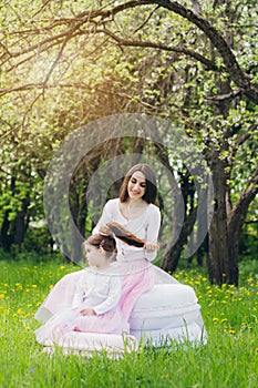 Mother and a little daughter walk in the spring blooming Apple