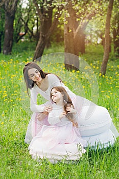 Mother and a little daughter walk in the spring blooming Apple