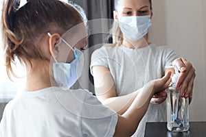 Mother and little daughter washing hand with alcohol sanitizer, prevent the virus and bacterias of Covid-19