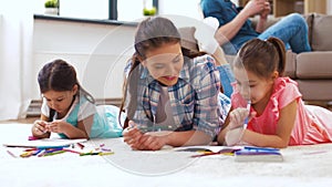 Mother with little daughters drawing at home