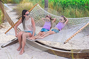 Mother and little daughters relaxing in hammock on