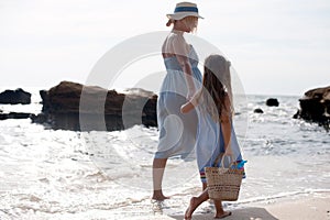 Mother and little girl hiking near sea