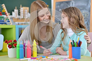 Mother and little girl painting at home