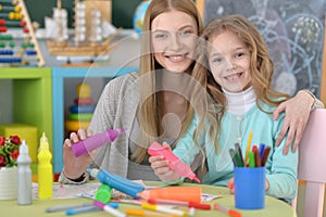 Mother and little girl painting at home