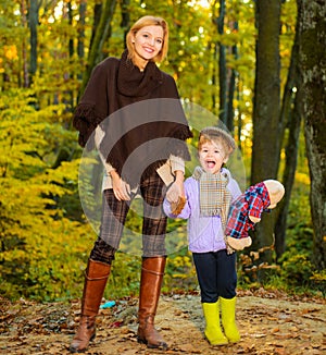 Mother with little son in autumn forest. Happy family spending time together walking in beautiful nature.