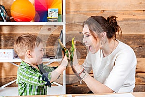 Mother and little son giving high five with painted hands