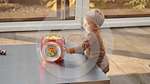 Mother and little son laughing and playing educational toys sitting on floor at home