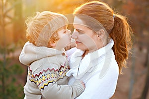 Mother and little son in park or forest, outdoors. Hugging and having fun together. Happy toddler boy and young mum, kid
