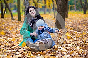 Mother with little son plays in autumn park