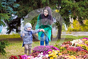 Mother with little son plays in autumn park